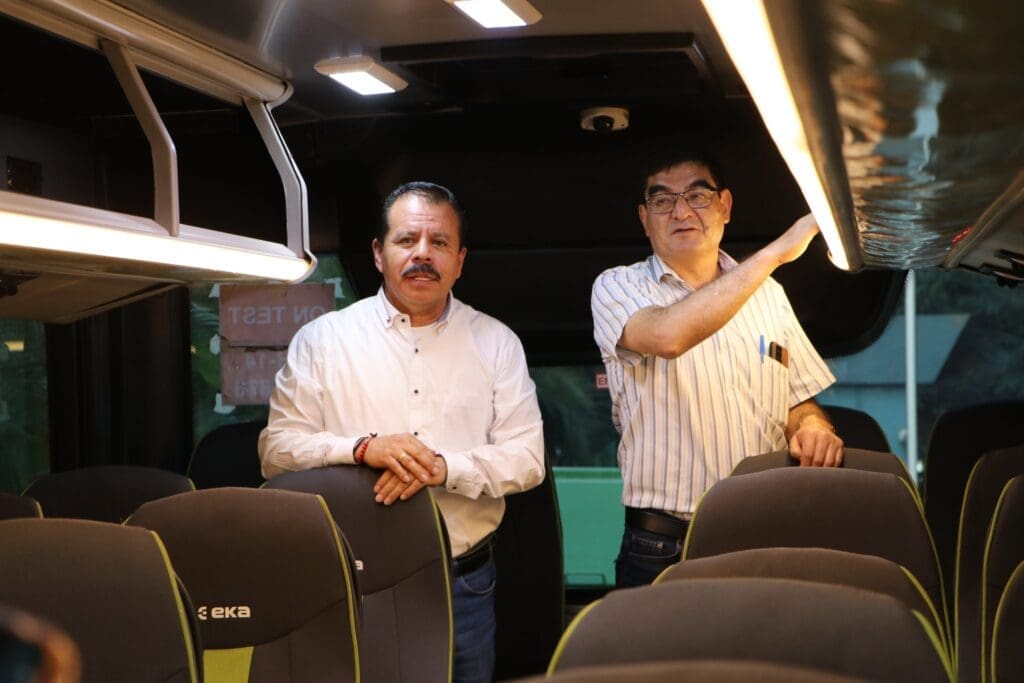 Los funcionarios Juan Fernando López (JF) y Mario Leonel Cifuentes, dentro uno de los buses modelo que buscan importar desde la Republica de India. 