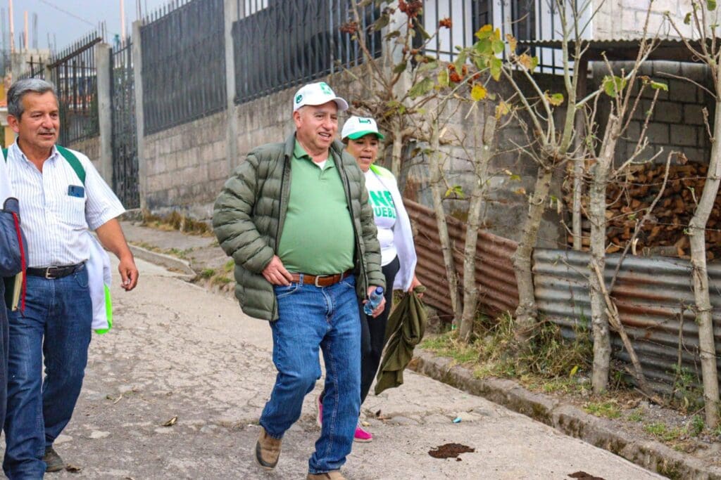 Aurelio Monzón camina junto a Armando Paniagua hacia una reunión con vecinos de la ciudad altense, como parte de las actividades electorales.