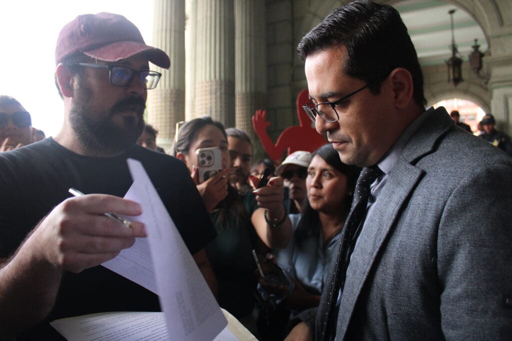Gabriel Rodríguez, artista independiente, entrega la carta a Juan Gerardo Guerrero, secretario general de la Presidencia. Créditos: Jimena Porres.