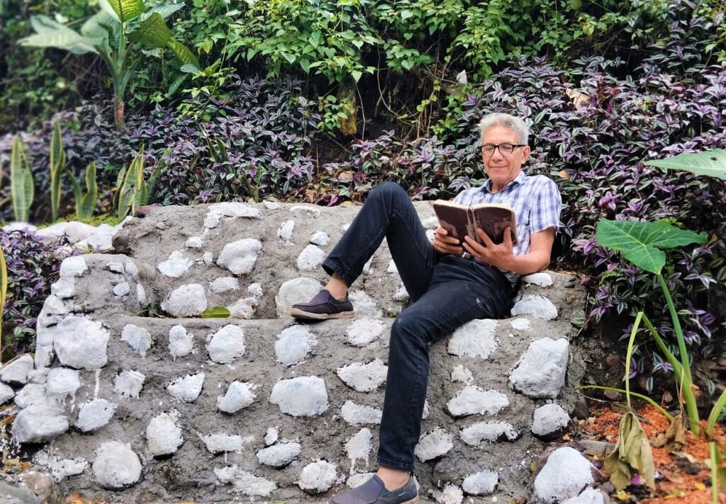 Oscar Argueta lee en el Paseo de la felicidad, obra que desarrolló con apoyo de algunos vecinos. Foto: Cortesía.
